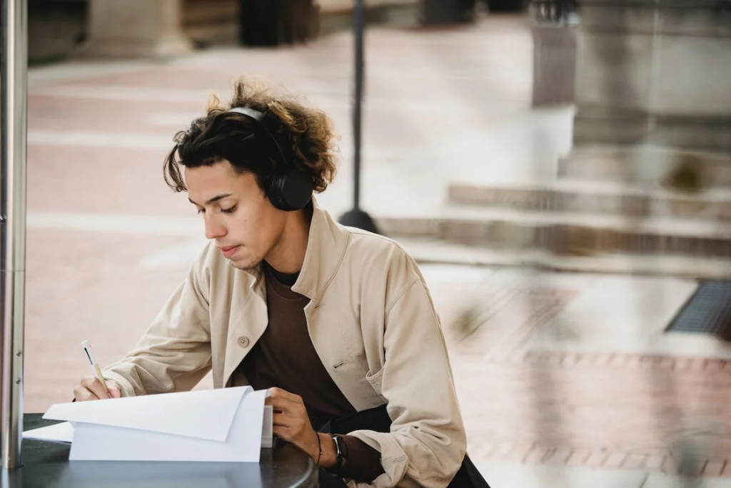 A Quick Look At How Transcribing Services Improve Efficiency And Productivity 3 Focused male student writing in document while doing homework