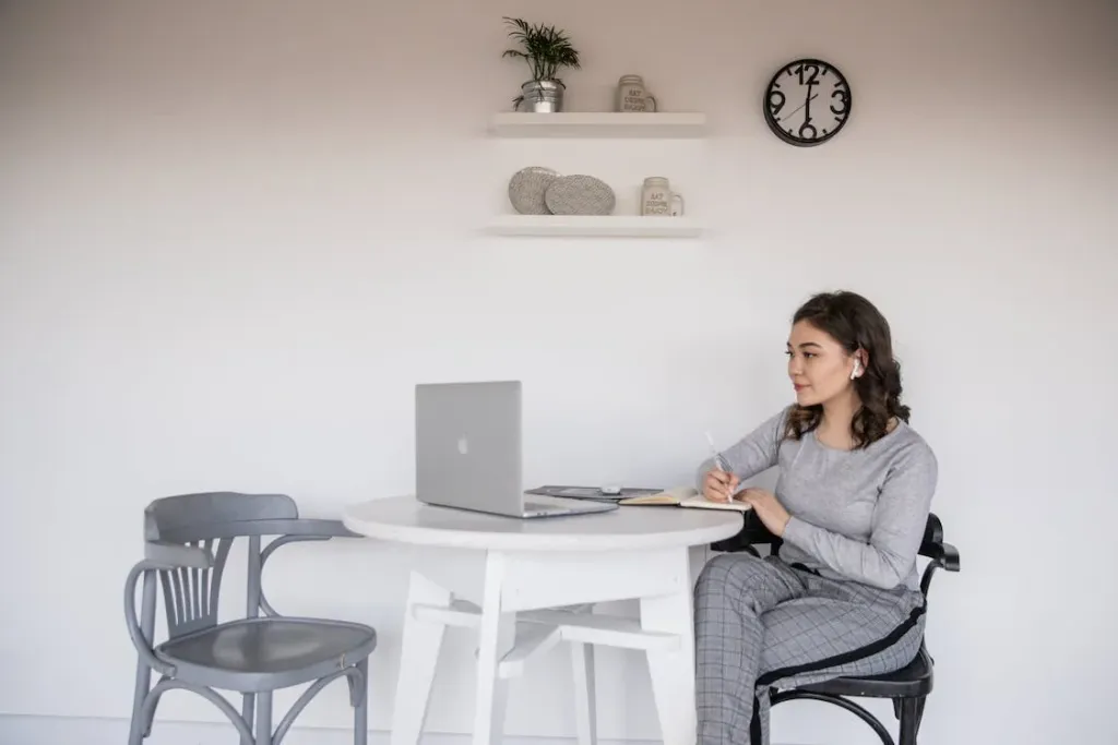 A Quick Look At How Transcribing Services Improve Efficiency And Productivity 5 Ethnic female student in earbuds writing on copybook near laptop