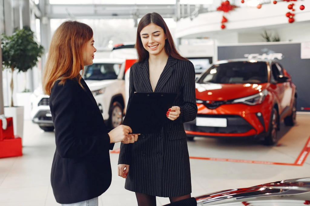 Guide To Buying A New Car: Key Considerations For Your Vehicle Purchase 1 Female Car Dealer Holding a Contract